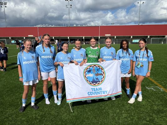 The ICG football team holding the Team Coventry Flag.